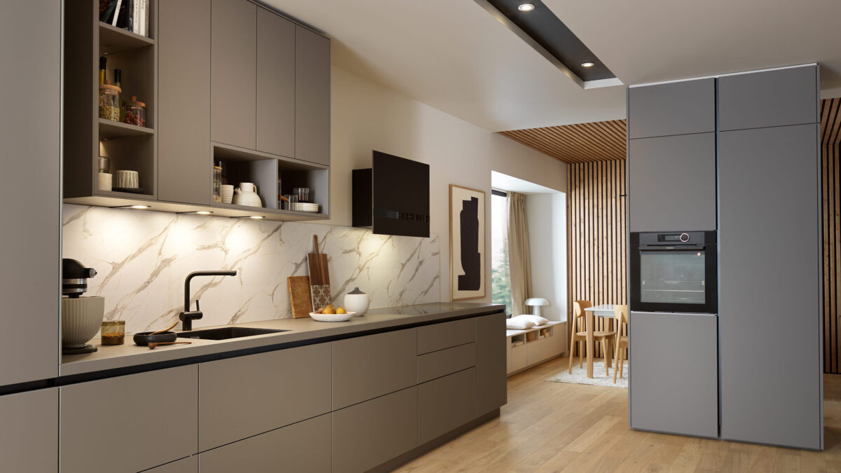 Grifflose Küche mit mattgrauen Schränken, Nischenrückwand in Marmoroptik, Unterschrankbeleuchtung, eingebautem Ofen und schwarzem Wasserhahn. Ein kleiner Essbereich mit einem Holztisch und Stühlen ist durch eine offene Tür sichtbar.