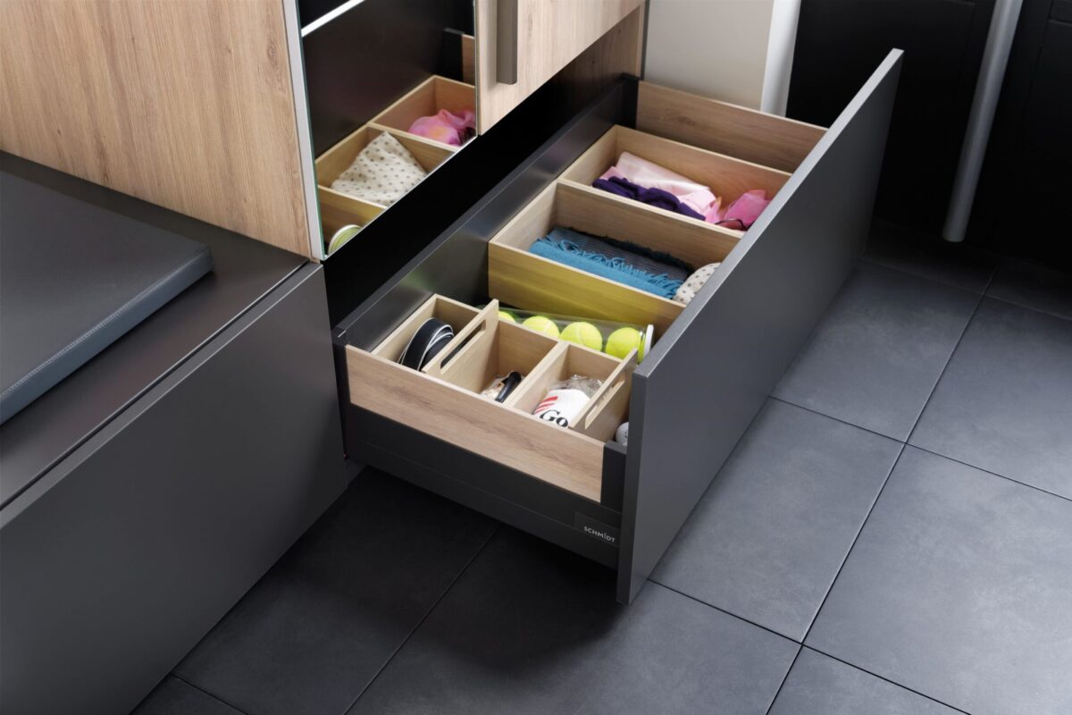 Der Garderobenschrank bietet viel Stauraum durch verschiedene ausziehbare Schubladen.