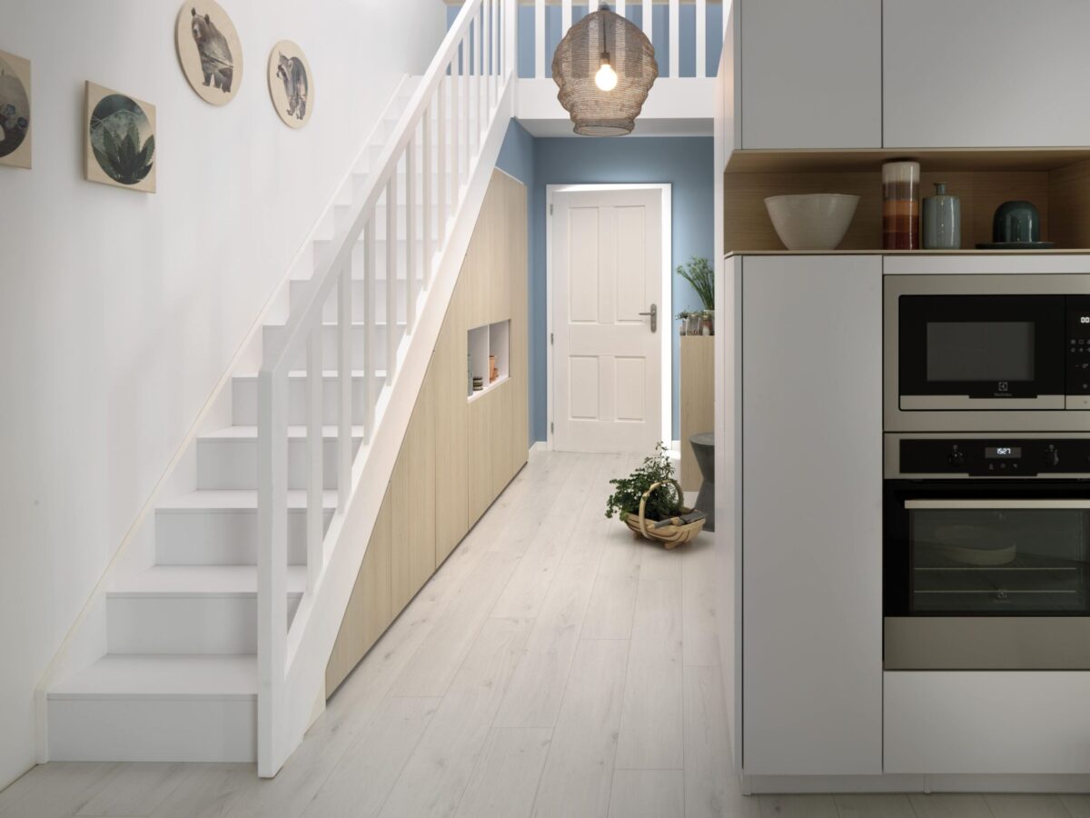 Im schmalen Flur ist kein Platz für Garderobenmöbel. Dafür wird der Platz unter der Treppe mit einem Einbauschrank optial genutzt.