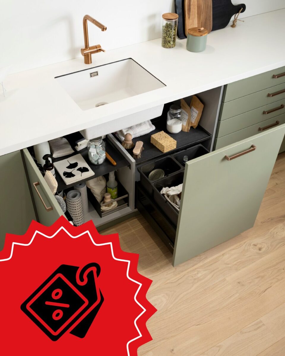Eine moderne Küchenspüle mit hellgrünen Schränken von SCHMIDT Küchenstudio und Wohnwelten lässt sich öffnen und gibt den Blick frei auf eine geordnete Ablage für Putzmittel, Schwämme und Bürsten. In der unteren linken Ecke ist ein rotes Rabattschild abgebildet.
